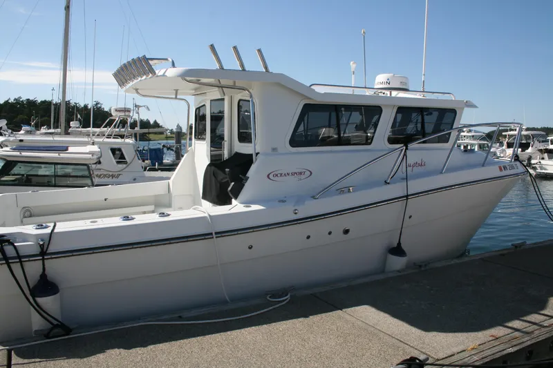 The Image of 2014 Ocean Sport 27' Legacy boat docked at marina under clear blue sky. - 0