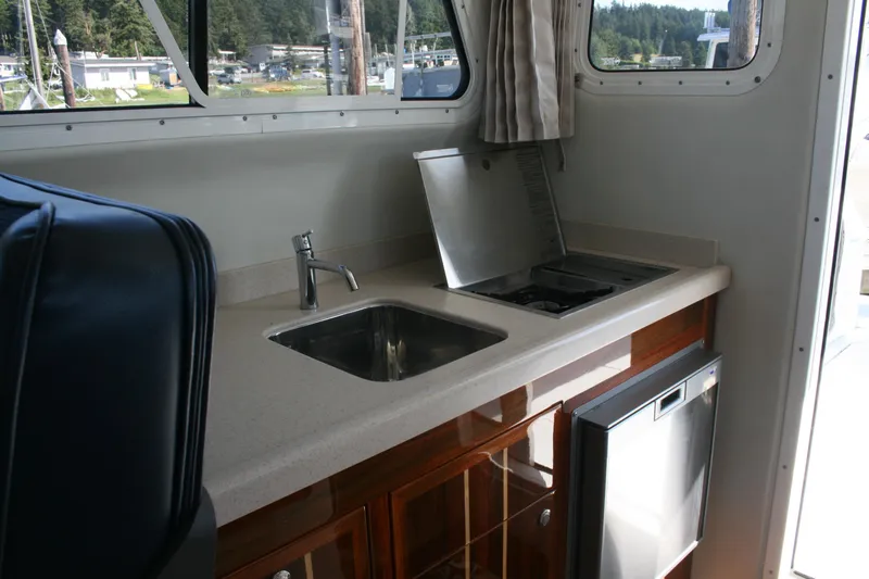 Slide: The Image of Interior of 2014 Ocean Sport 27' Legacy boat featuring a compact kitchen area. - 10