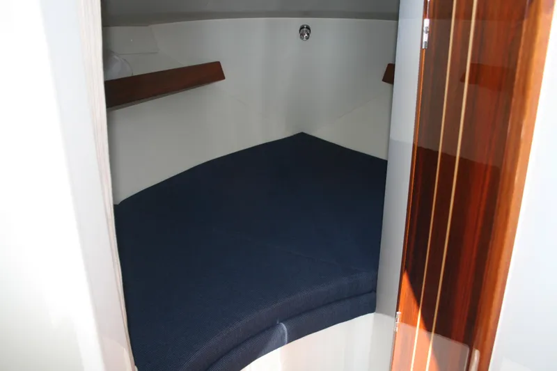 Slide: The Image of 2014 Ocean Sport 27' Legacy cabin interior with blue cushioned berth. - 11