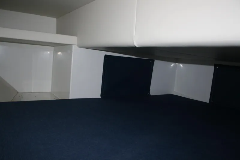 Slide: The Image of Interior cabin of 2014 Ocean Sport 27' Legacy boat, featuring sleek white surfaces. - 13