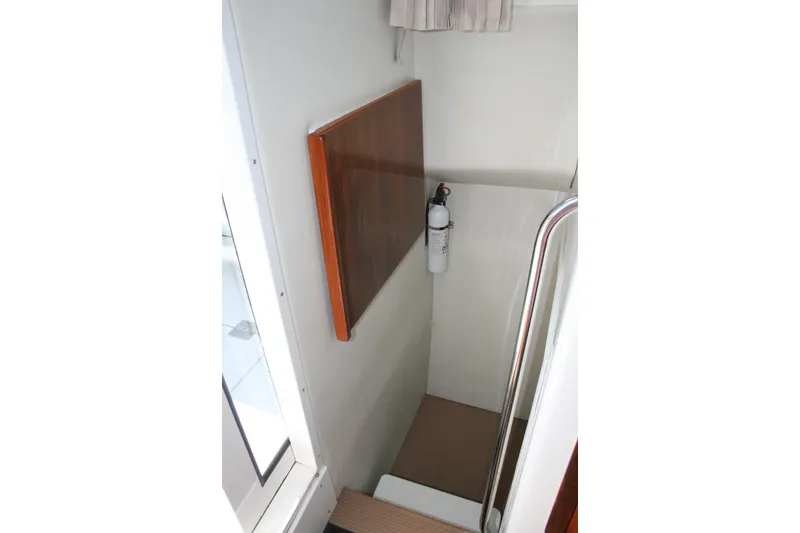Slide: The Image of Interior of 2014 Ocean Sport 27' Legacy boat with fire extinguisher and wooden panel. - 16