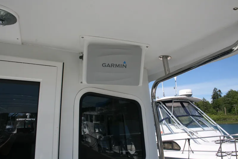 Slide: The Image of 2014 Ocean Sport 27' Legacy boat with Garmin equipment, docked near other vessels. - 17