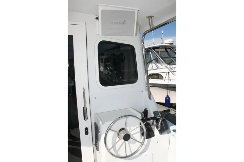 Slide: The Image of Steering area of a 2014 Ocean Sport 27' Legacy boat with Garmin equipment. - 3