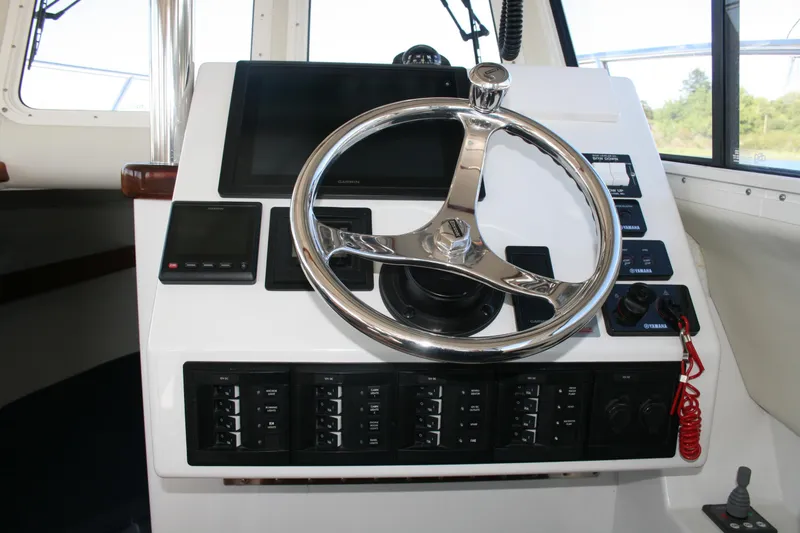 Slide: The Image of Steering console of a 2014 Ocean Sport 27' Legacy boat with navigation controls. - 5