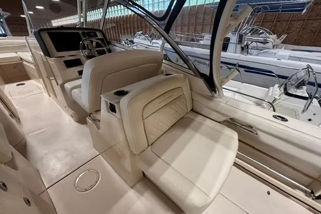 Slide: The Image of 2022 Grady-White Freedom 285 boat interior with beige seating and steering console. - 11