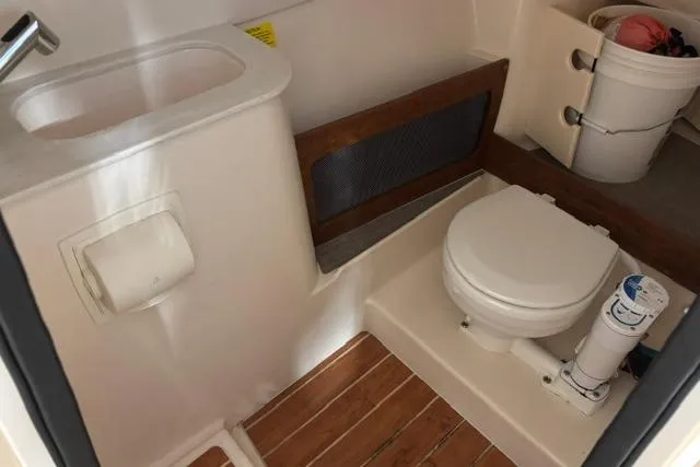 Slide: The Image of 2022 Grady-White Freedom 285 boat bathroom with toilet, sink, and wooden flooring. - 23