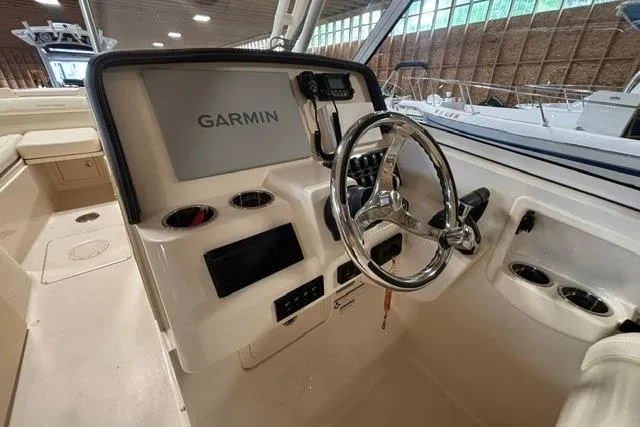 Slide: The Image of 2022 Grady-White Freedom 285 boat dashboard with Garmin navigation system and steering wheel. - 8