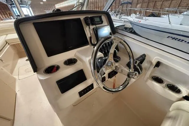 Slide: The Image of 2022 Grady-White Freedom 285 boat helm with steering wheel and control panel. - 9