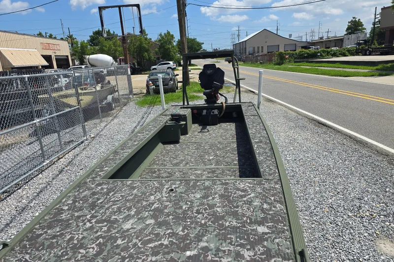 Slide: The Image of 2015 Gator Tail 1854 boat with camouflage deck, parked on gravel near a road. - 5