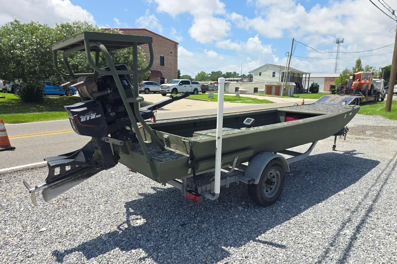 Slide: The Image of 2015 Gator Tail 1854 boat on trailer, parked on gravel, under a sunny sky. - 7