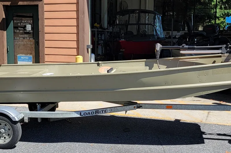 Slide: The Image of 2015 Tracker Topper 1542 LW Riveted Jon boat on Load Rite trailer outside service shop. - 12