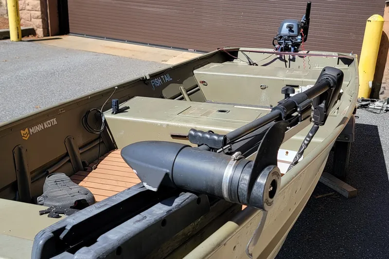 Slide: The Image of 2015 Tracker Topper 1542 LW Riveted Jon boat with Minn Kota motor in a driveway. - 3