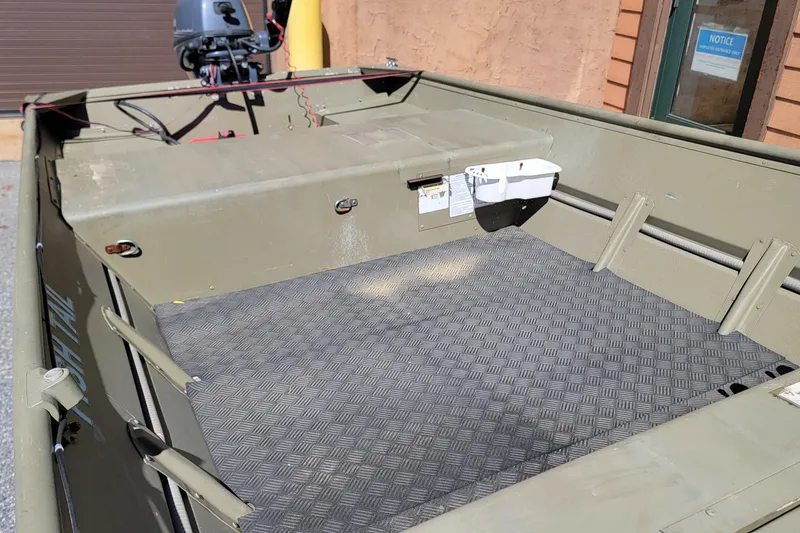 Slide: The Image of 2015 Tracker Topper 1542 LW Riveted Jon boat with motor, featuring a textured floor. - 5