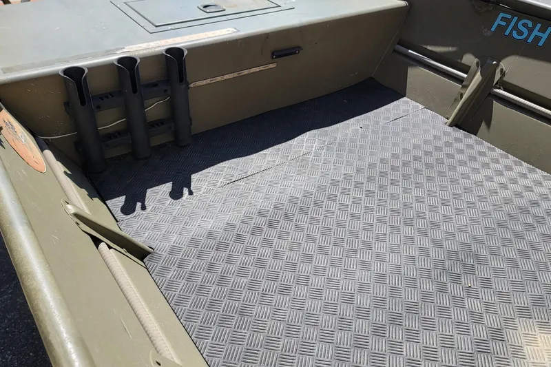 Slide: The Image of 2015 Tracker Topper 1542 LW Riveted Jon boat interior with rod holders and textured flooring. - 9