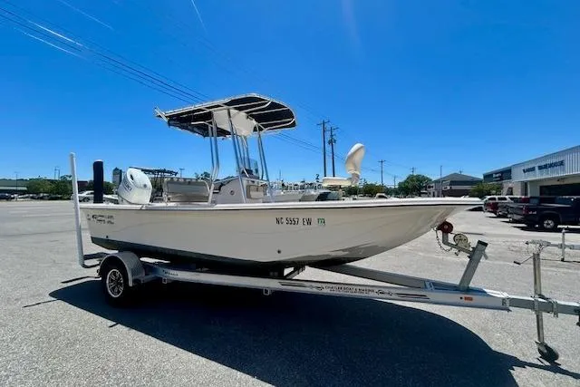 The Image of 2022 Carolina Skiff 21 LS boat on trailer in parking lot under clear blue sky. - 0