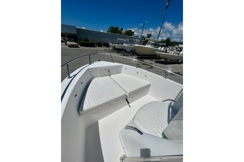 Slide: The Image of 2022 Carolina Skiff 21 LS boat interior with white seating, parked outdoors. - 10