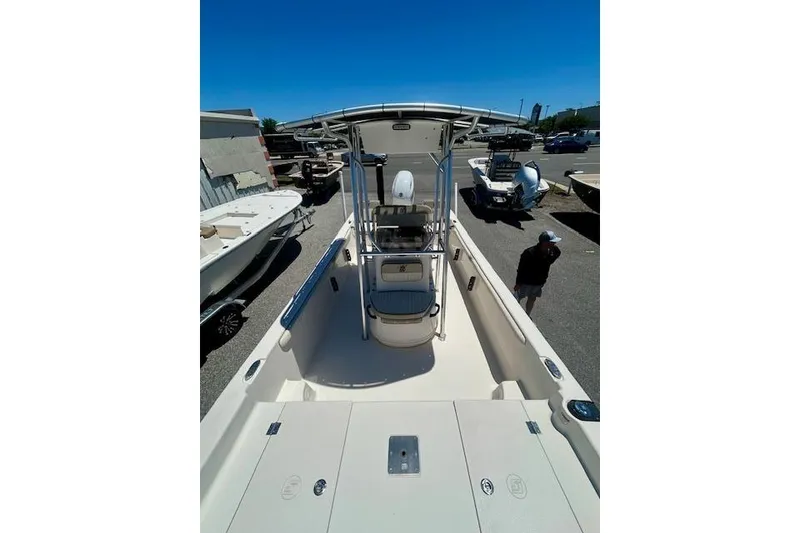 Slide: The Image of 2022 Carolina Skiff 21 LS boat with center console and T-top in a parking lot. - 12