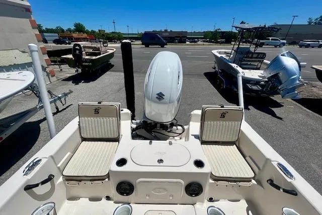 Slide: The Image of 2022 Carolina Skiff 21 LS boat interior with seating and motor in a parking lot. - 18