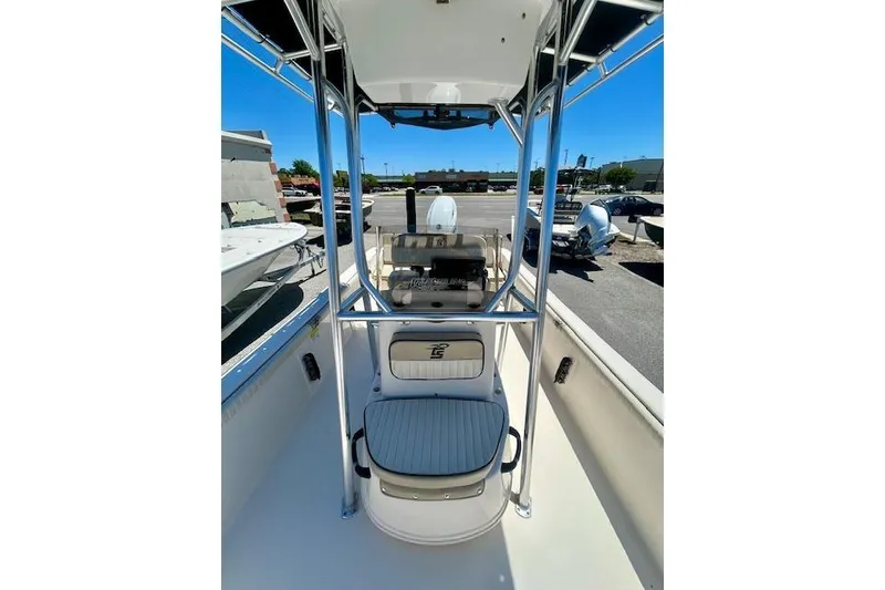 Slide: The Image of 2022 Carolina Skiff 21 LS boat interior with seating and console, parked outdoors. - 19