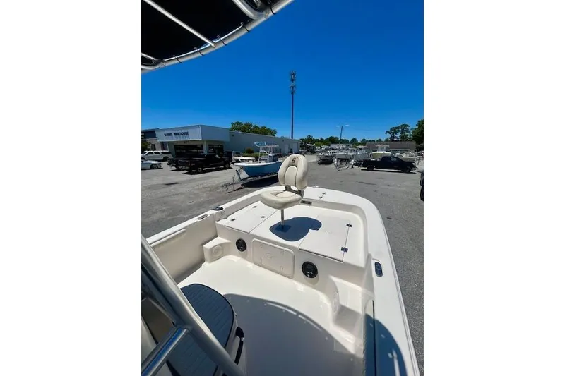 Slide: The Image of 2022 Carolina Skiff 21 LS boat with seating, parked outdoors under clear blue sky. - 3