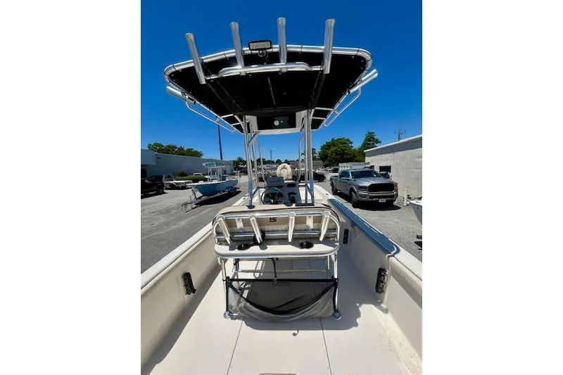 Slide: The Image of 2022 Carolina Skiff 21 LS boat with T-top and rod holders, parked outdoors. - 4