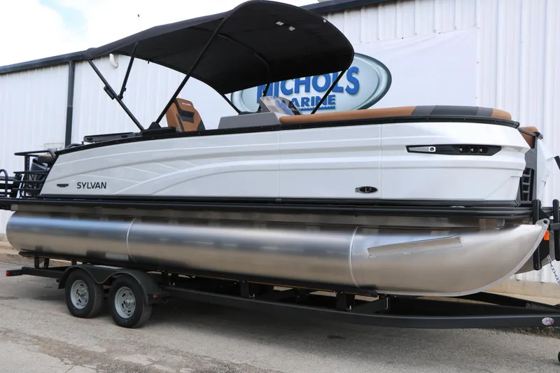 The Image of 2026 Sylvan L3 DLZ Bar Platinum Edition Tri-Toon boat on trailer, side view. - 0