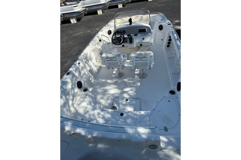 Slide: The Image of 2015 Hurricane SunDeck Sport CC 231 OB boat interior with dual seats and steering console. - 4