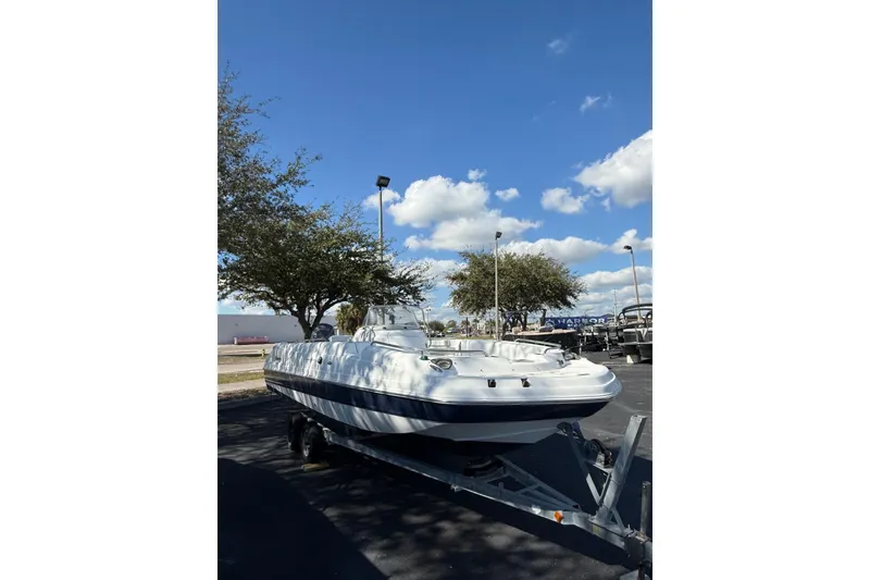 Slide: The Image of 2015 Hurricane SunDeck Sport CC 231 OB boat on trailer under blue sky. - 5