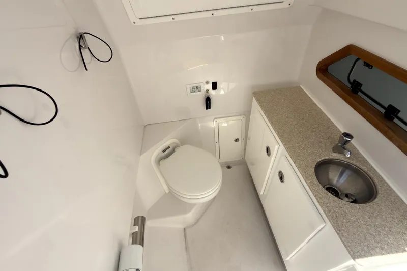Slide: The Image of 2023 Bertram 28 CC boat interior with toilet, sink, and storage cabinets. - 14