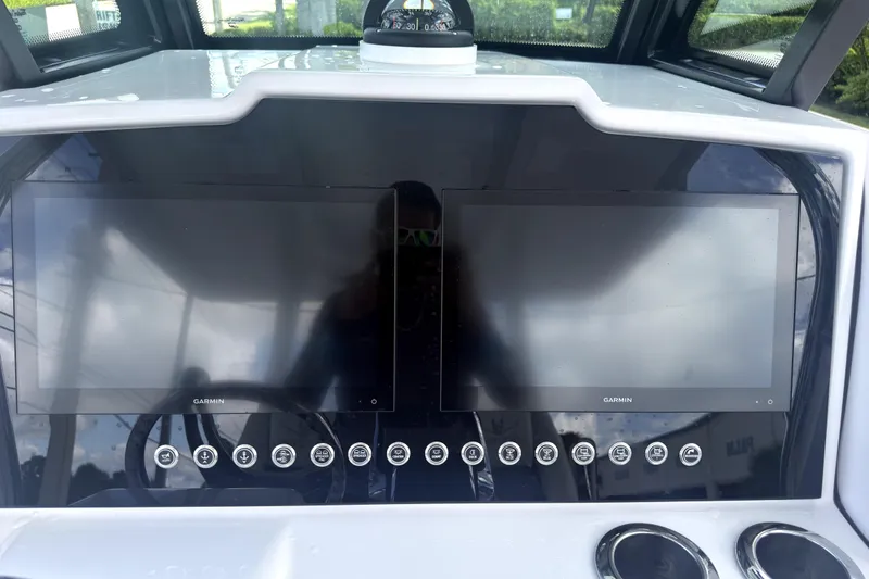 Slide: The Image of 2023 Bertram 28 CC dashboard with dual Garmin displays and control buttons. - 17