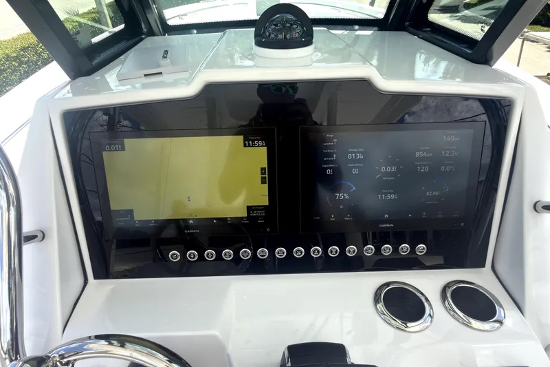 Slide: The Image of 2023 Bertram 28 CC boat dashboard with dual Garmin displays and compass. - 20