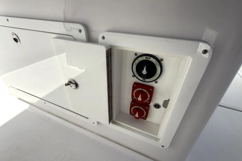 Slide: The Image of Control panel on a 2023 Bertram 28 CC boat, featuring switches and dials. - 23