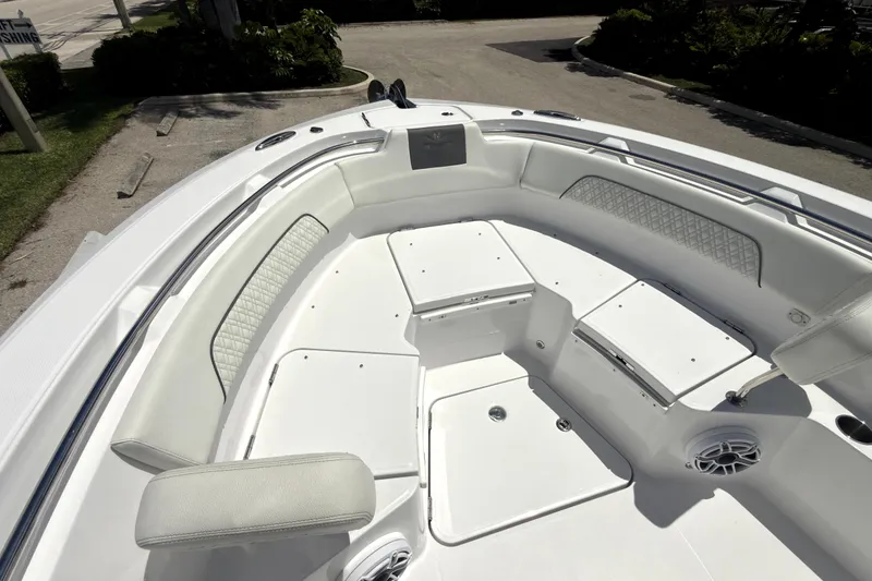 Slide: The Image of 2023 Bertram 28 CC boat interior with white seating and storage compartments. - 25