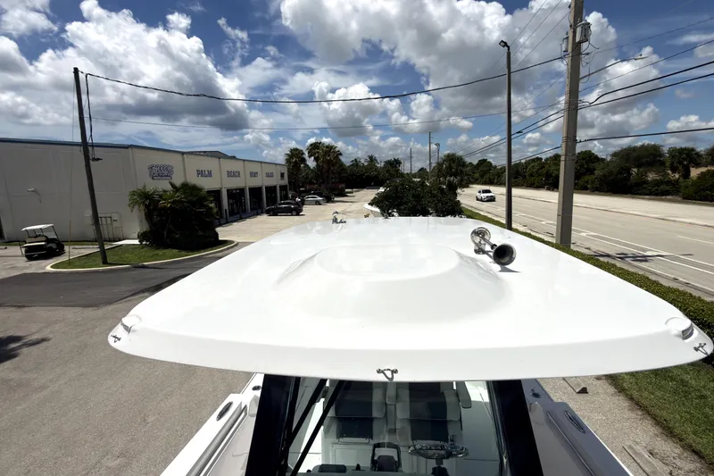 Slide: The Image of 2023 Bertram 28 CC boat roof view under a partly cloudy sky. - 27