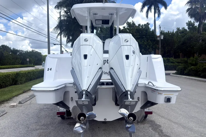 Slide: The Image of 2023 Bertram 28 CC boat with dual outboard engines, parked on a sunny day. - 3