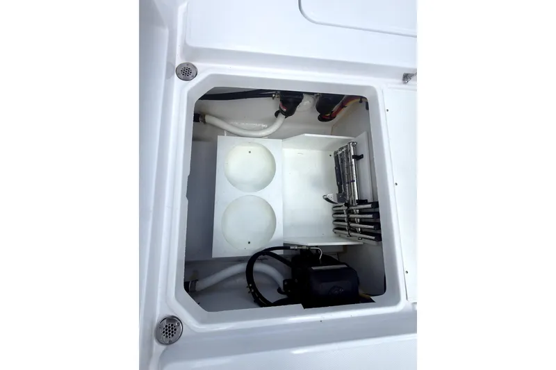 Slide: The Image of 2023 Bertram 28 CC boat storage compartment with organized equipment and wiring. - 34