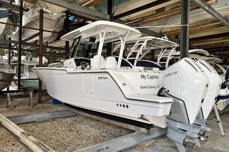 Slide: The Image of 2023 Bertram 28 CC boat in storage, featuring twin Mercury engines. - 5