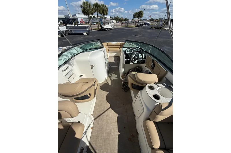 Slide: The Image of 2020 NauticStar 243 DC boat interior with beige seating and steering console. - 2