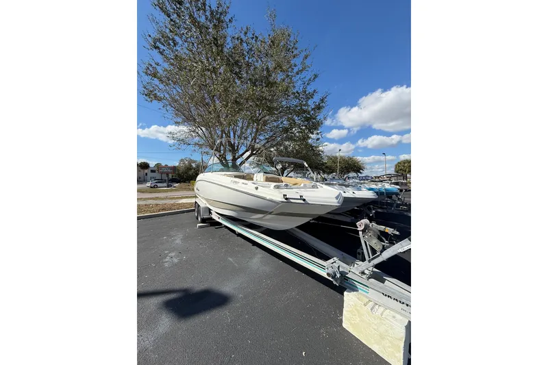 Slide: The Image of 2020 NauticStar 243 DC boat on trailer under clear blue sky. - 6