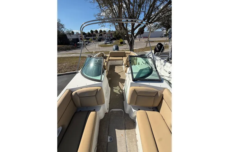 Slide: The Image of 2020 NauticStar 243 DC boat interior with tan seating and windshield. - 8