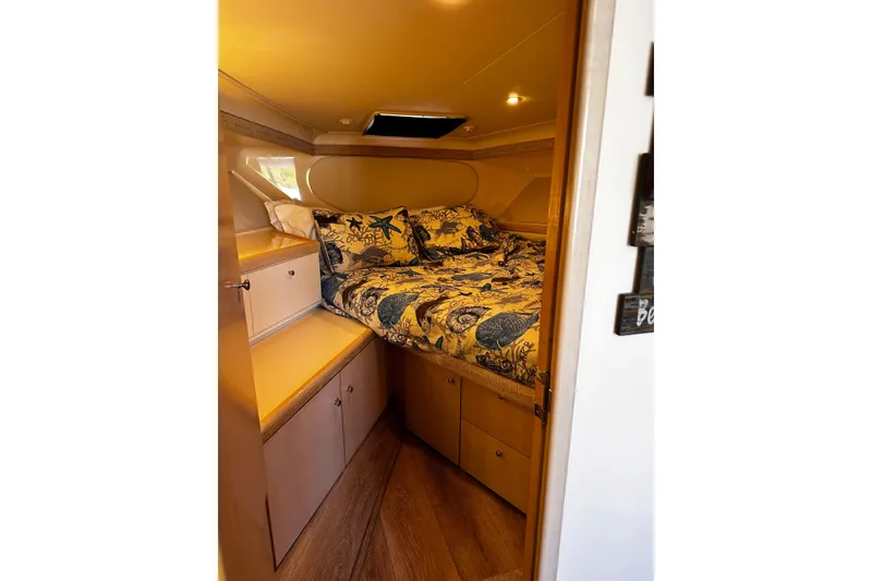 Slide: The Image of Cozy cabin interior of 1998 Carver 350 Mariner with nautical-themed bedding. - 10