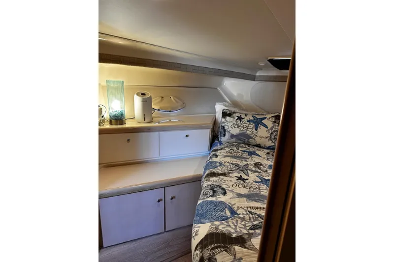 Slide: The Image of Cozy cabin interior of 1998 Carver 350 Mariner with nautical-themed bedding and ambient lighting. - 11