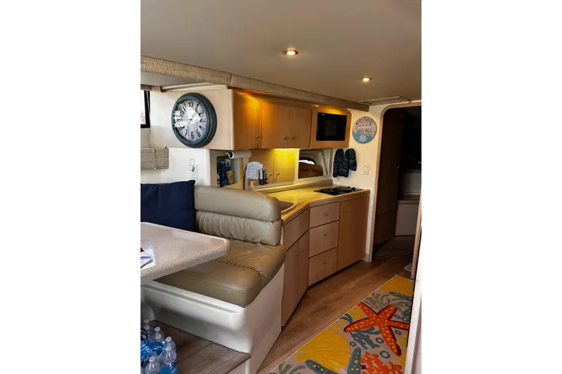 Slide: The Image of Interior of a 1998 Carver 350 Mariner yacht with cozy seating and kitchenette. - 12