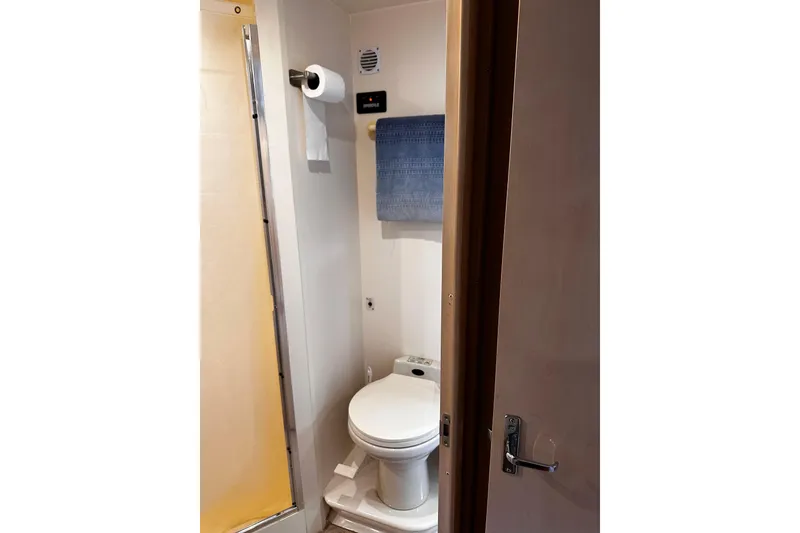 Slide: The Image of Compact bathroom in a 1998 Carver 350 Mariner yacht, featuring a toilet and towel rack. - 14
