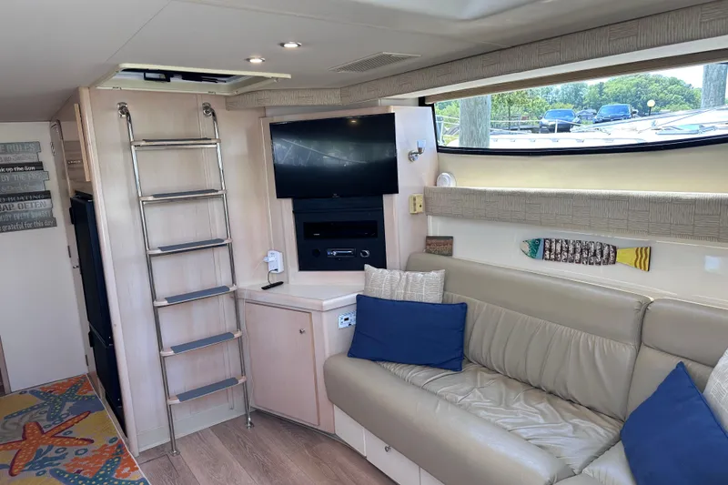 Slide: The Image of Interior of 1998 Carver 350 Mariner yacht with sofa, TV, and ladder. - 18