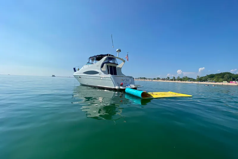 Slide: The Image of 1998 Carver 350 Mariner yacht anchored near a beach on a sunny day. - 2