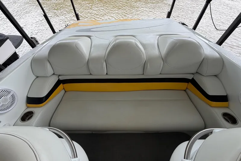 Slide: The Image of 2001 Baja 33 Outlaw boat interior with white and yellow seating, near water. - 12