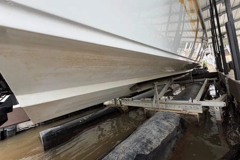 Slide: The Image of 2001 Baja 33 Outlaw boat on lift, showing hull and dock structure. - 27