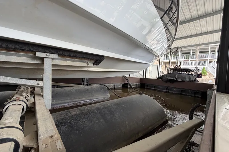 Slide: The Image of 2001 Baja 33 Outlaw boat on lift in covered dock area. - 28