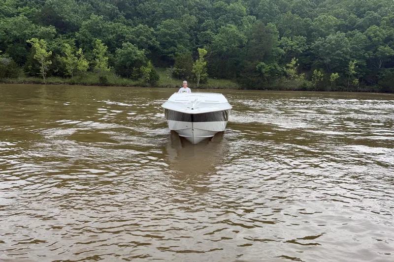 Slide: The Image of 2001 Baja 33 Outlaw boat cruising on a river with forested background. - 3